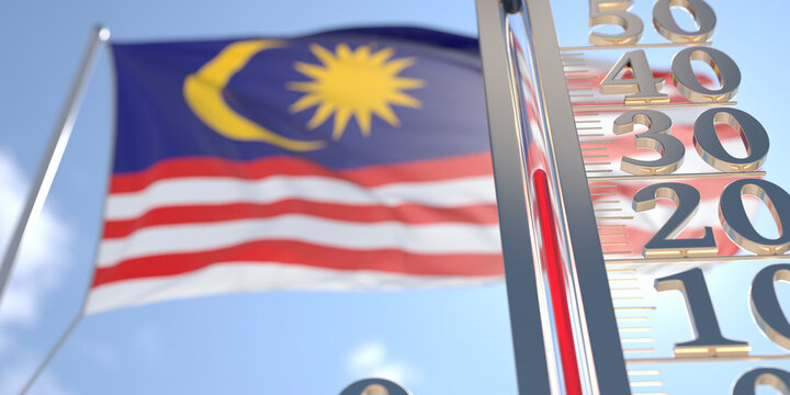 30 degrees centigrade on a thermometer measuring air temperature near flag of Malaysia. Hot weather forecast related 3D rendering