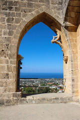 Bellapais Abbey arch with views of Kyrenia, the sea and the bright blue sky. White Abbey, the Abbey of the Beautiful world...