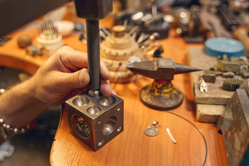 Experienced craftsman treating a piece of metal