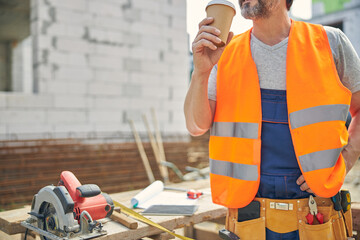 Male worker having a coffee break outdoors