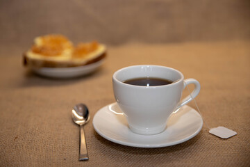white mug with tea and jam sandwiches