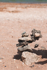 sandy beach on the sea pyramid of stones on the background of the sea balance of stones