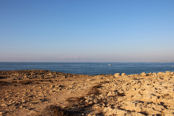 A stony, lifeless beach against the sea and blue sky. Ayia Napa. Cyprus.
