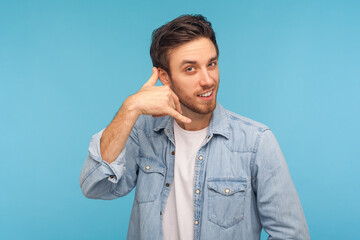 Call me! Portrait of cheerful handsome man in denim shirt standing with telephone hand gesture and...