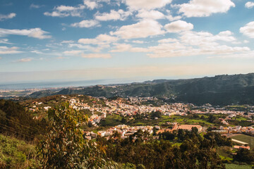 Obraz premium Landscape of a lake among the hills in Gran Canaria Island with rocks, bushes, different type of flowers, trees and cloudy sky mixed with intense blue color