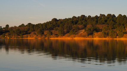 Coucher de soleil sur un lac, créant des teintes orangées