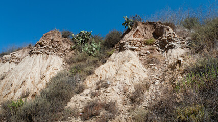 Layers of sand and a band of large rocks make up the geography of the foothills near Ventura, California.