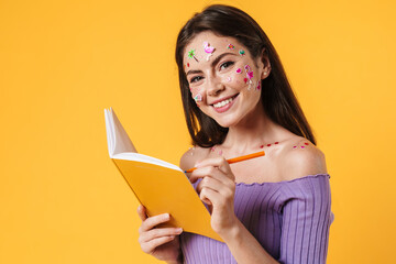 Image of young smiling woman writing in exercise book