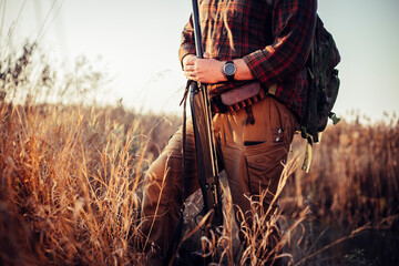 Masculine hunters hands, holding shotgun, in the sunset light, waiting for the duck