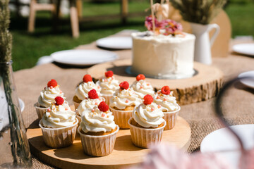 cupcakes with cream on a wooden tray outside