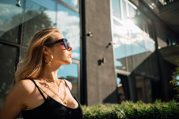 Portrait of beautiful young girl outdoors on hot, sunny, summer day, happy woman in sun glasses