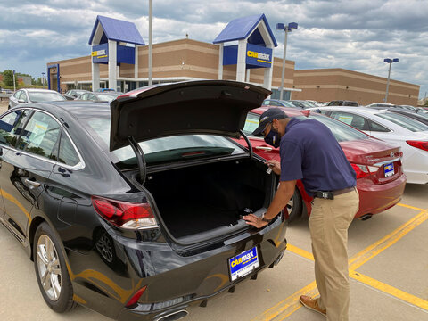 Brandon Parrum, general manager of CarMax's Des Moines store, shows off one of the many vehicles that customers can arrange to buy online and collect at the store
