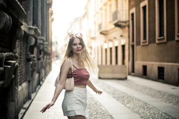 Obraz na płótnie Canvas Blonde girl is walking in the city