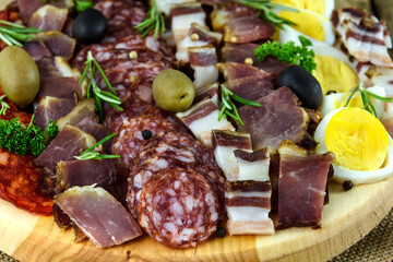 Sliced meat and sausage on a wooden board