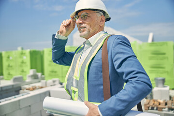 Civil engineer holding blueprints in his hand