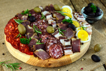 Sliced meat and sausage on a wooden board