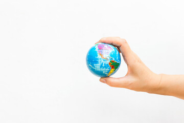 World map foam Earth Globe stress relief bouncy ball in girl hand on white background, world news or environmental
