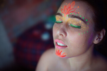 Portrait of painted woman in fluorescent powder and paint.