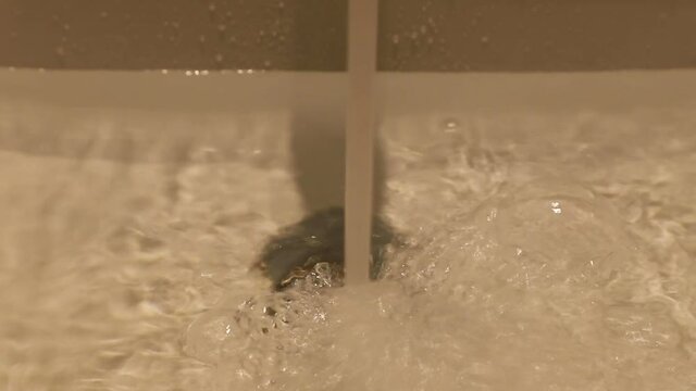 water pours from tap into sink in shower room in a hotel