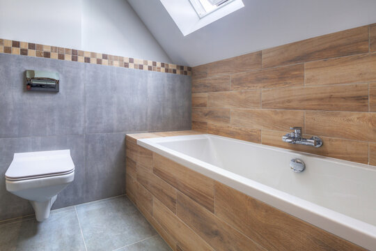 New bathroom interior in the house. Gray concrete tiles with wooden decor.