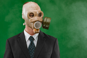 Portrait of a man wearing a dark business suit and a gas mask, isolated on green background with fog.