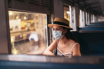 Young brunette woman traveling in Thailand on train during pandemic Coronavirus. 20s Hispanic in a...