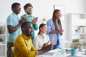 Fototapeta na wymiar Portrait of multi-ethnic business team applauding and smiling while listening to presentation or celebrating success in office, copy space