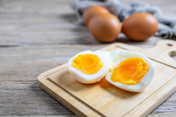 Boiled eggs and raw eggs on a wooden table