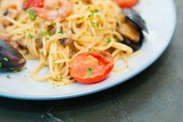 Spaghetti pasta with shrimp, mussels, tomatoes and cheese, close-up, copy space. Tasty, traditional food from Italy