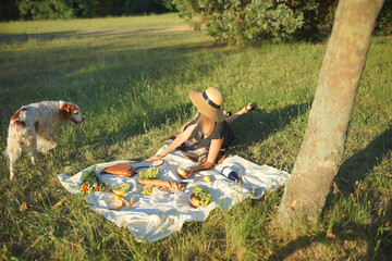 A young woman enjoying a picnic with a dog