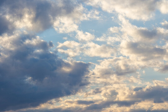 clouds in yellow sunset light. blue sky background in the evening