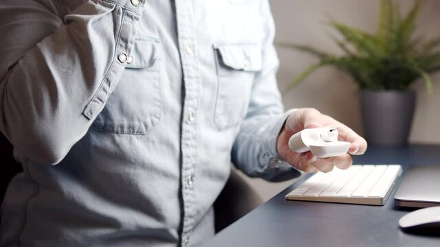 Close up of male using wireless headphones at the workspace