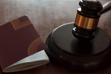 Judge's gavel and passport on wooden table