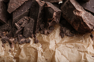 Pieces of dark chocolate on parchment, closeup