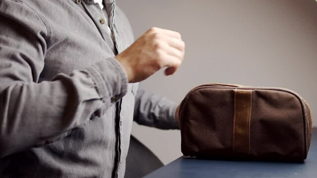 Travel essentials during pandemic, male pack hand sanitizer and face masks to protect from coronavirus during holidays