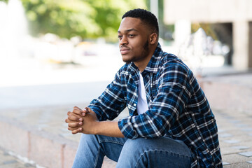 Portrait of african american guy sitting on the steps