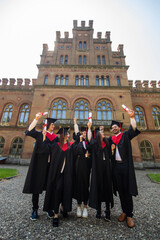 Happy graduates. Five college graduates standing in a row and smiling.