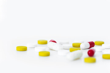 Close-up of multicolored medicines scattered on white table. Pharmaceutical drug isolated copy space minimalistic background