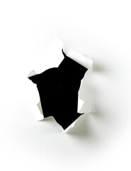 Ripped hole in white paper with black background