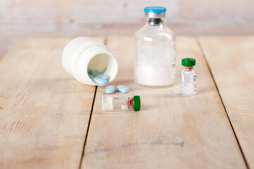 Various pill bottles and different pills on wooden table