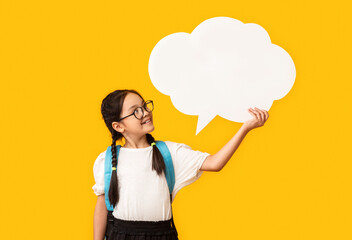 Asian Schoolgirl Holding Blank Speech Bubble Posing Over Yellow Background