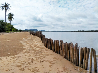A typical wooden fence along the barrier sand dunes in Thailand.