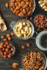 Bowls with different nuts on wooden background. Vitamin food