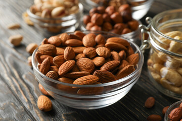 Bowls with different nuts on wooden background. Vitamin food