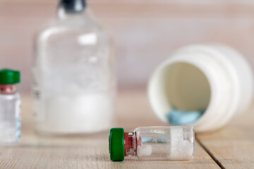 Various pill bottles and different pills on wooden table