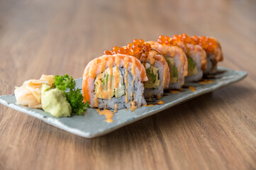 California salmon sushi rolls stuffed with salmon, avocado, topping salmon roe and spicy cream sauce. Japanese food style