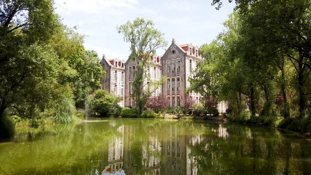 The old military headquarters and high school college building reflected over the lake at Parque D. Carlos I, in Caldas da Rainha, Silver Coast, Portugal