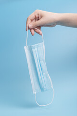 Holding a blue mask on a blue background