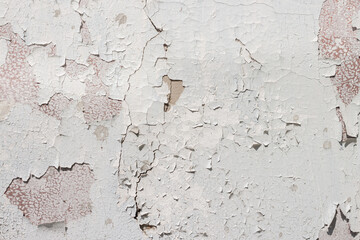 Grunge weathered shabby white peeled painted concrete surface of the wall with holes, dirty and cracks macro