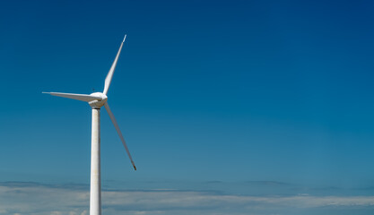 Fototapeta na wymiar Wind turbine on blue sky with copy space